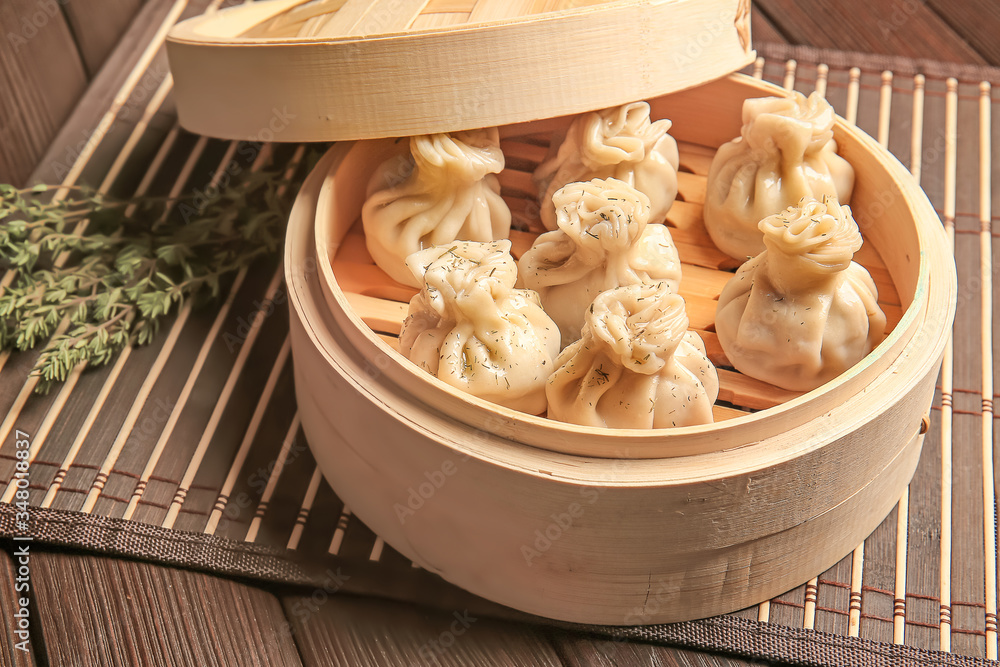 Steamer with tasty dumplings on table