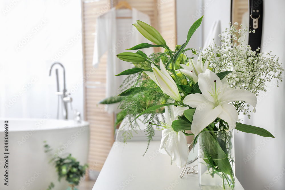 Vase with flowers in modern bathroom