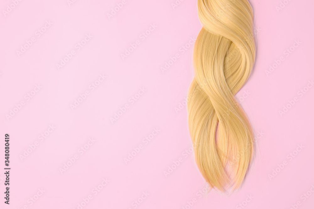 Beautiful long blonde hair on color background