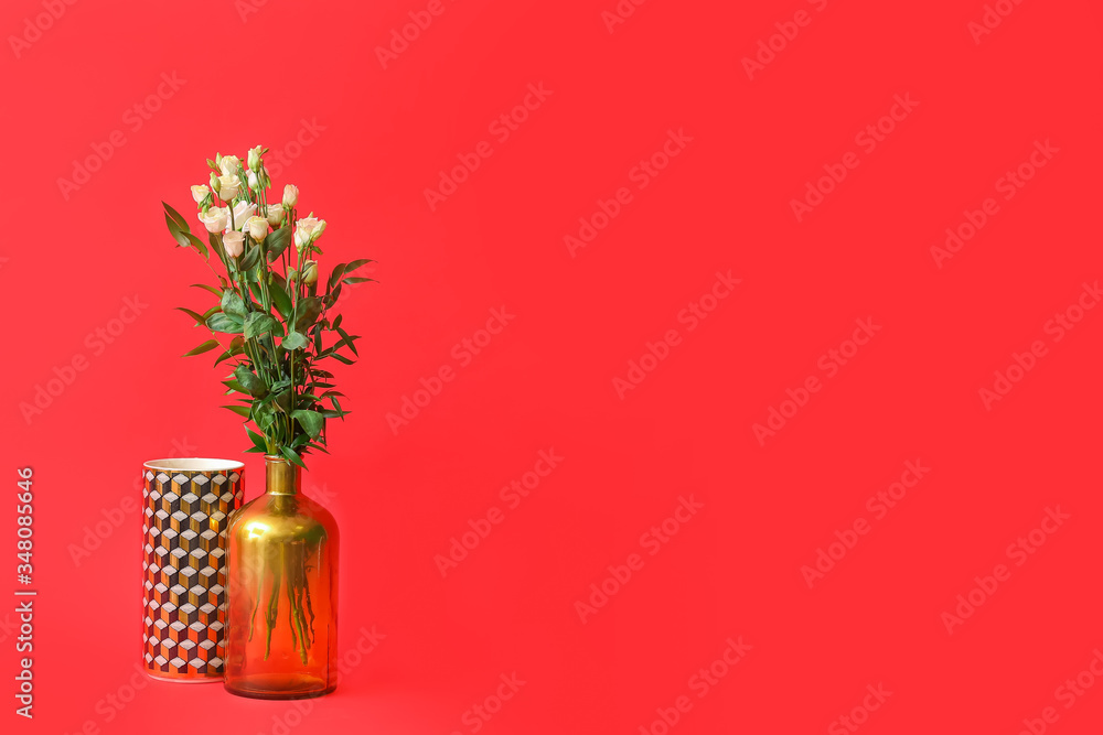 Different vases with bouquet of flowers on color background