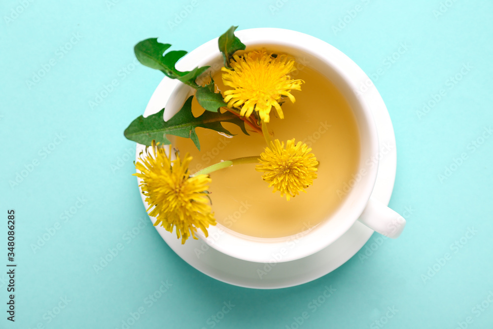 Cup of healthy dandelion tea on color background