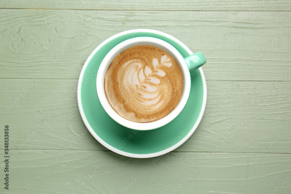 Cup of tasty cappuccino on wooden background