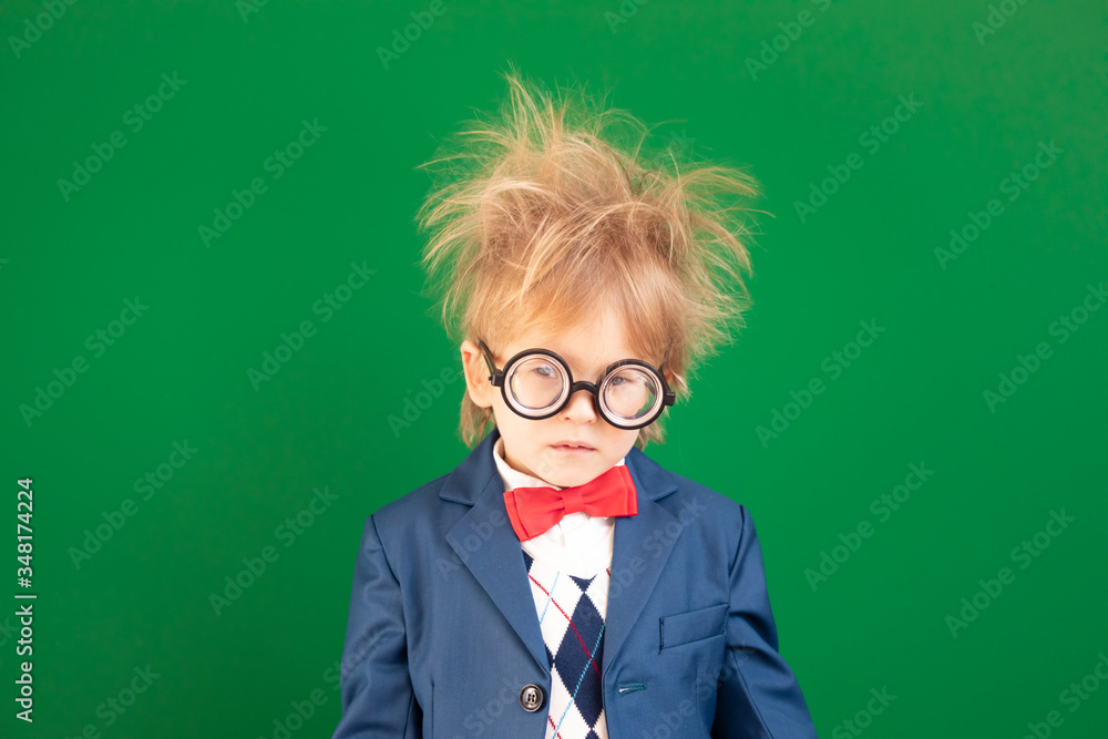 Bright idea! Serious child student against green chalkboard