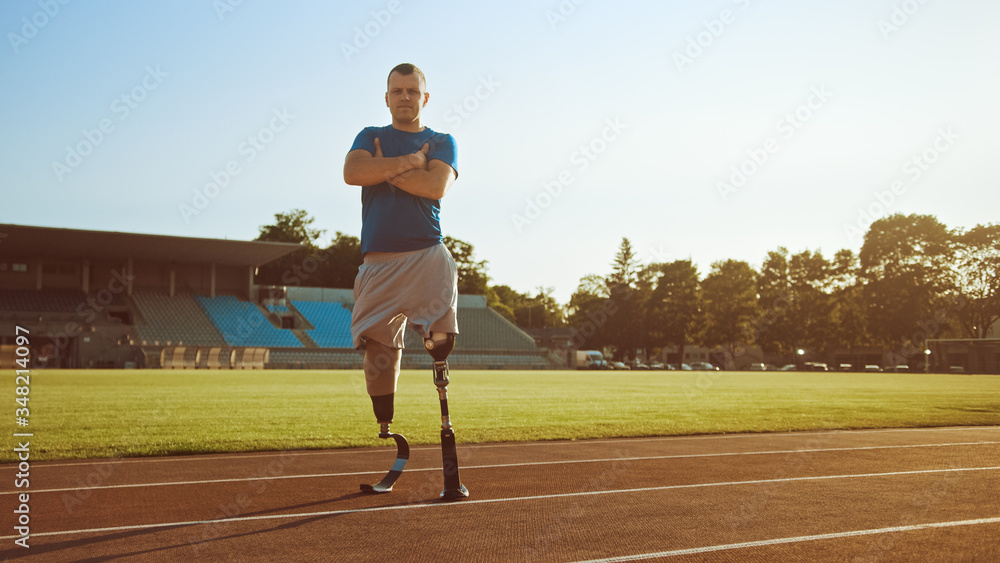 Athletic Disabled Fit Man with Prosthetic Running Blades is Posing with Crossed Arms on an Outdoor S