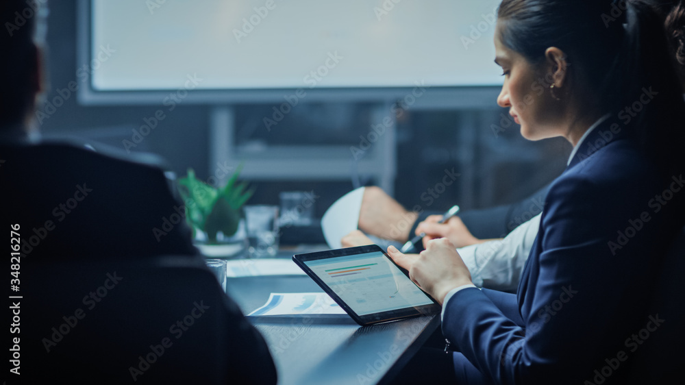 In the Corporate Meeting Room: Young Business Associate Sits at the Conference Table and Uses Digita