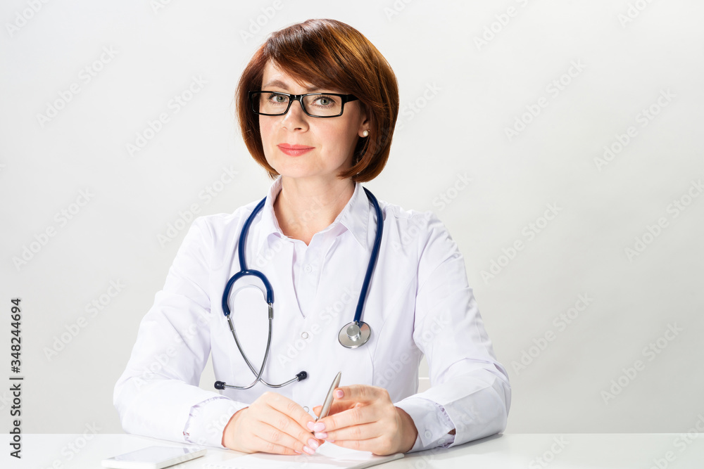 Attractive redhead doctor sitting in office