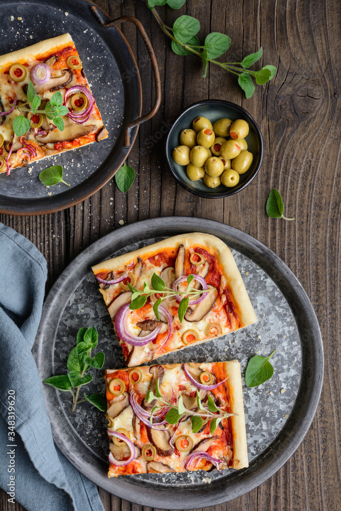 Homemade healthy Shiitake mushroom pizza topped with slices with green olives, cheese, red onion and