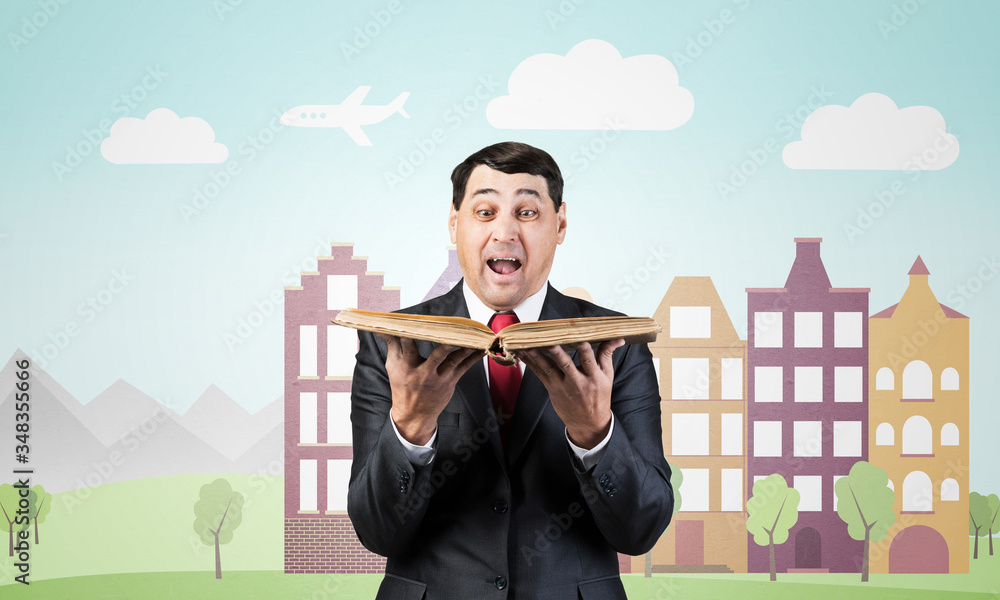 Surprised businessman holding open old book