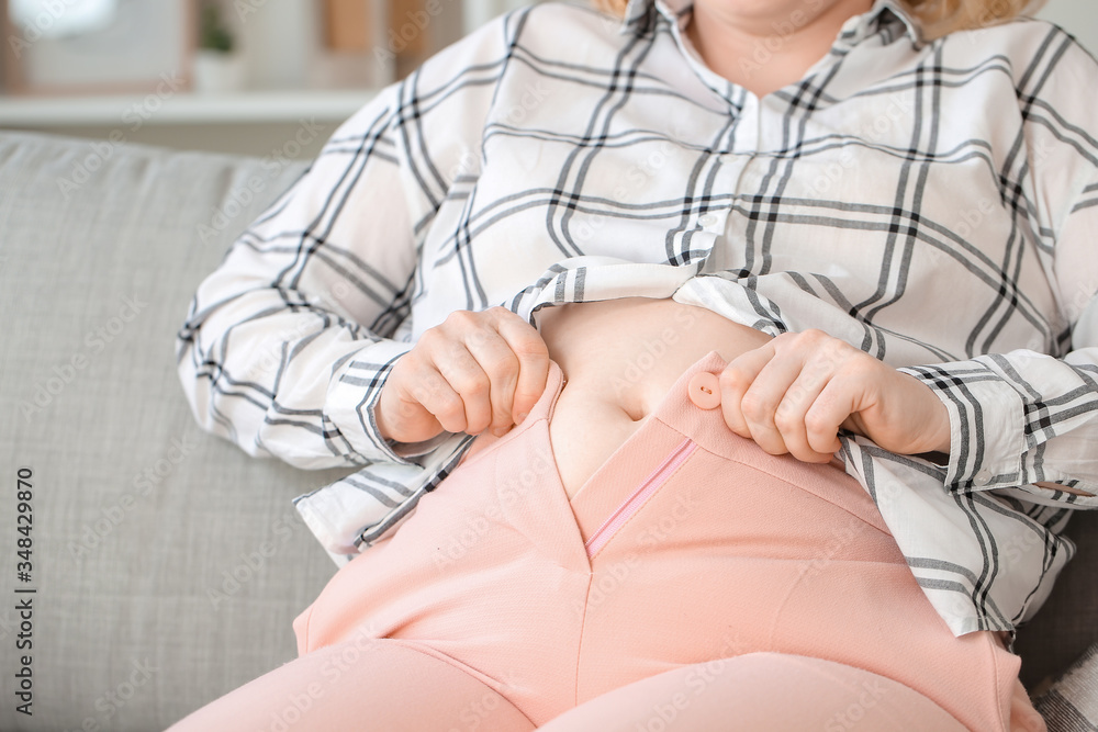 Overweight woman in tight clothes at home, closeup