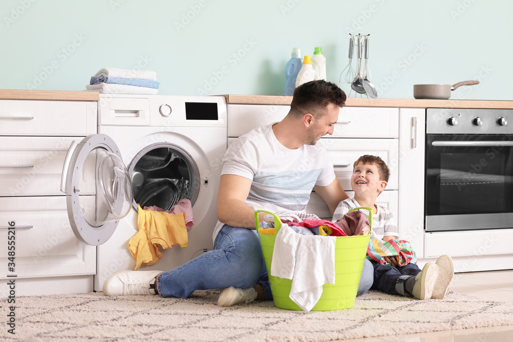 Man and his little son doing laundry at home