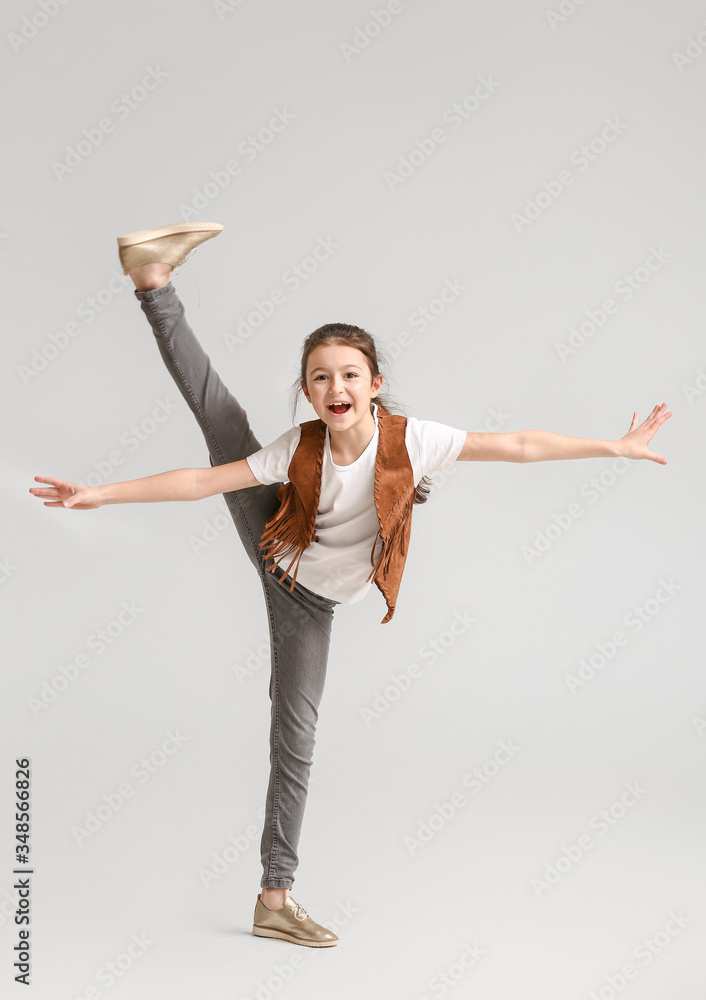 Cute dancing girl on light background