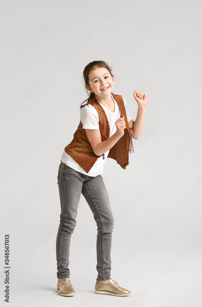 Cute dancing girl on light background