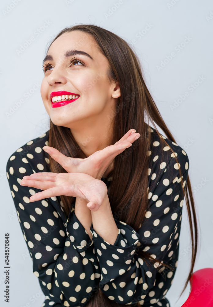 快乐的漂亮女孩笑着把手放在脸附近。看着旁边。漂亮女人的智慧