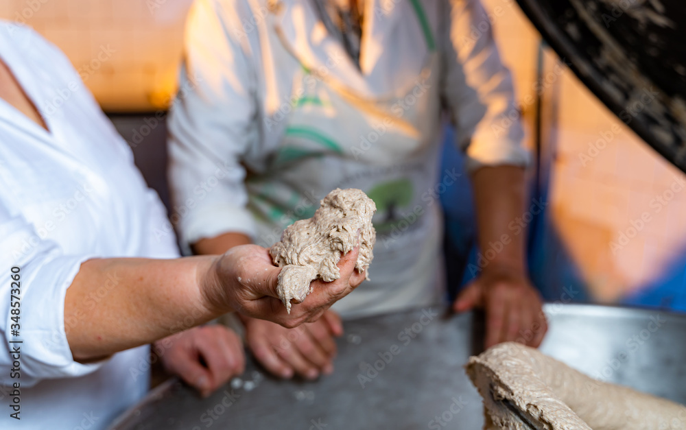 Cooker`s hands holding raw puff pastry. Checking puff pastry. First step of professional production.