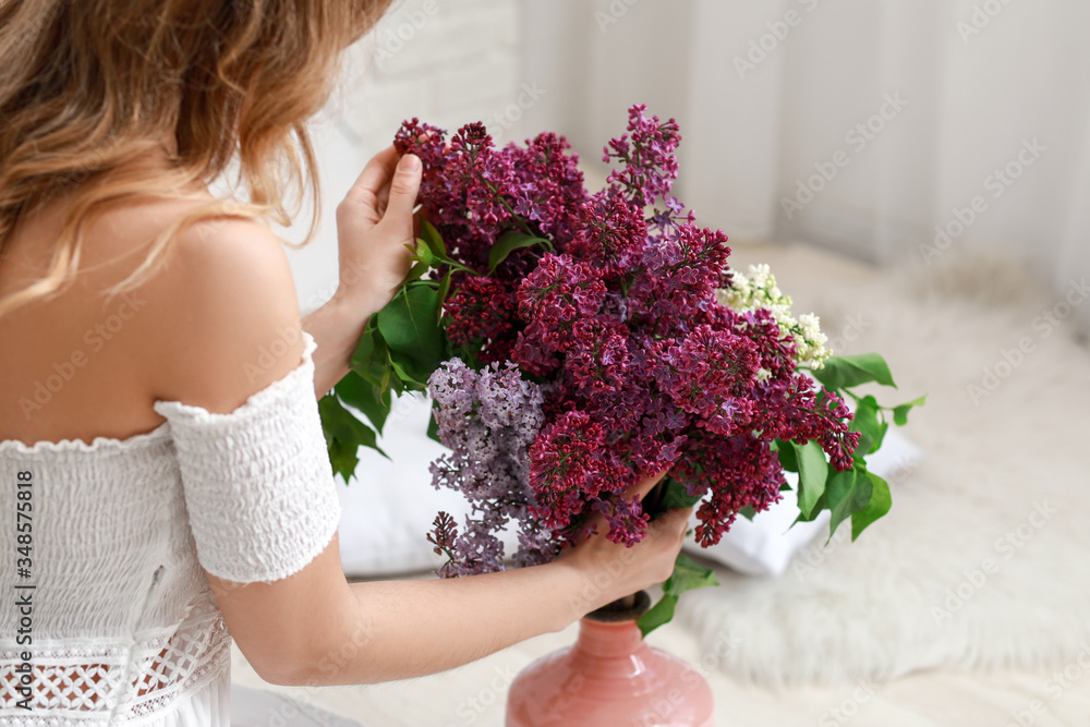 家里有一束丁香花的漂亮年轻女人