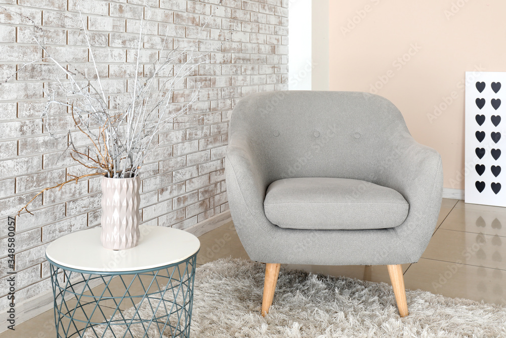 Comfortable armchair and table in interior of living room