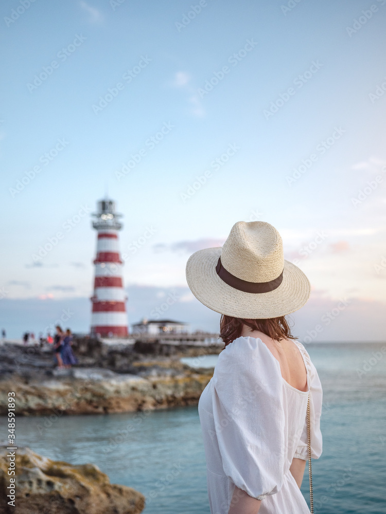 Young woman on the background of a beacon