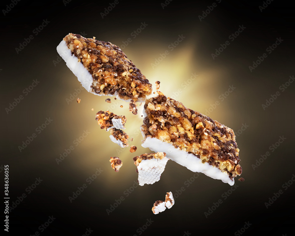 Energy cereal bars broken into two halves with a flash of light in the dark