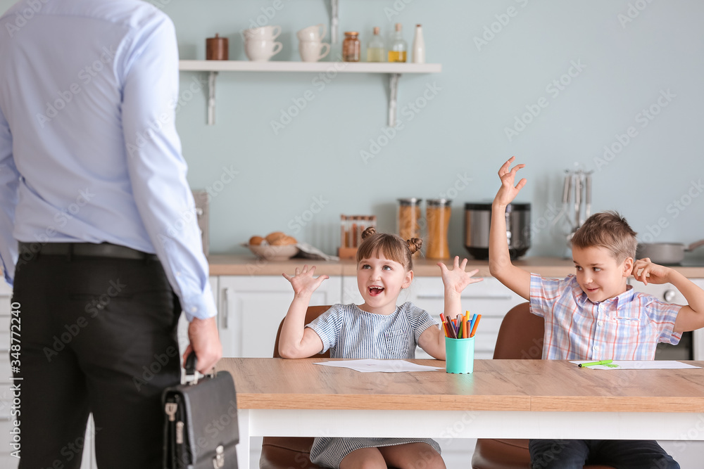 Happy children meeting their father after work at home