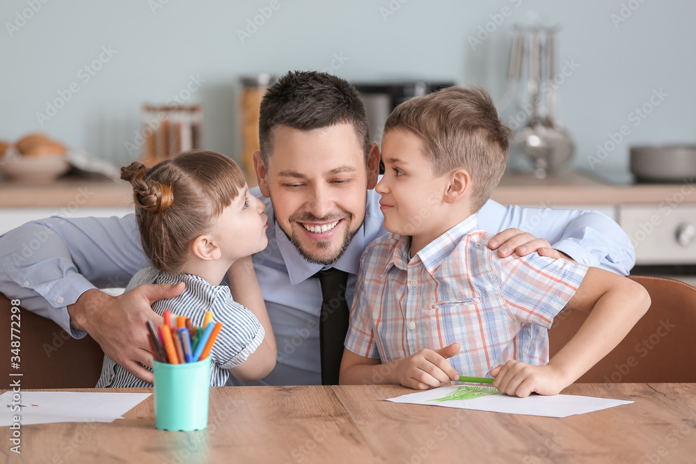 Happy children with father in kitchen at home