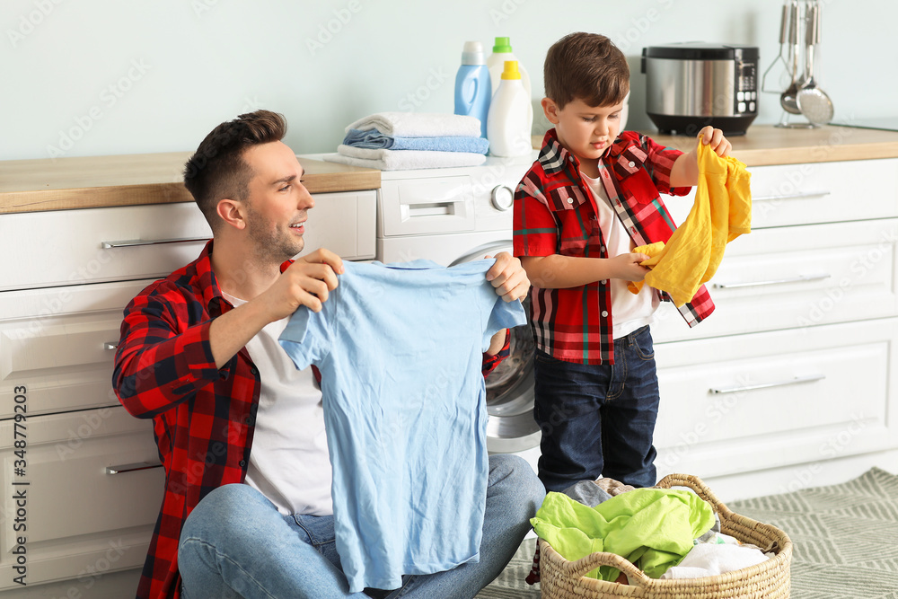 Man and his little son doing laundry at home