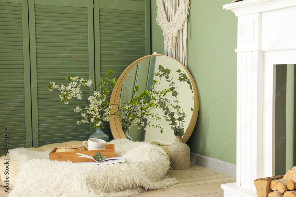 Cozy place for rest with mirror and blooming tree branches