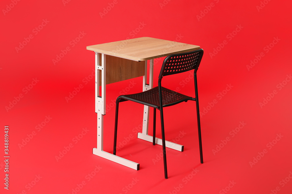 School desk with chair on color background