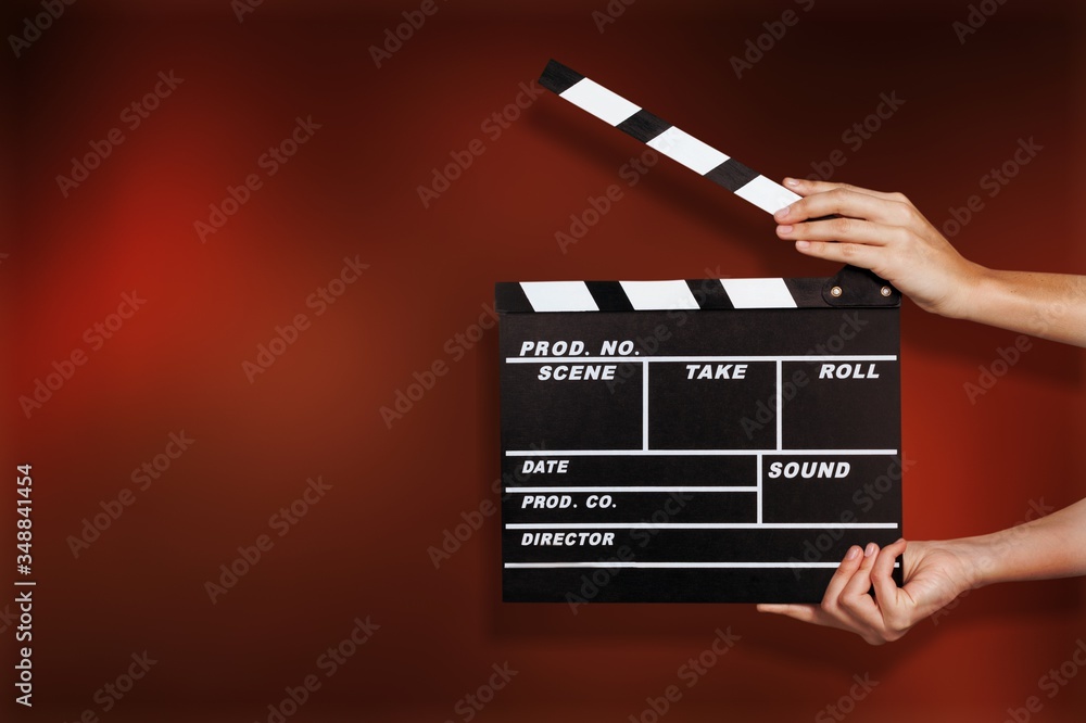 Female hands using classic film clapperboard