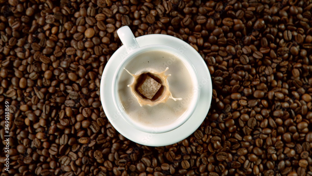 Falling sugar canes into cup of hot coffee