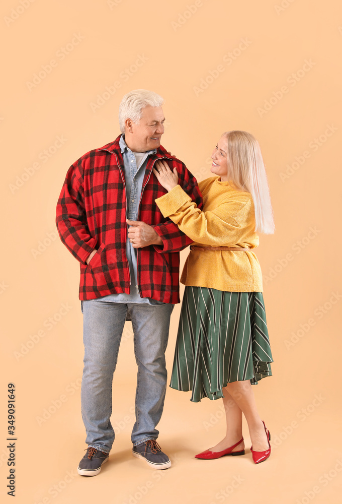 Portrait of happy elderly couple on color background