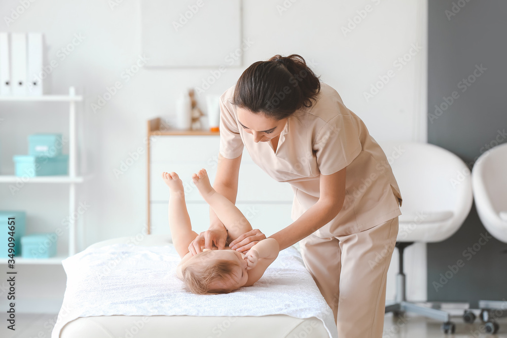 Massage therapist working with cute baby in medical center