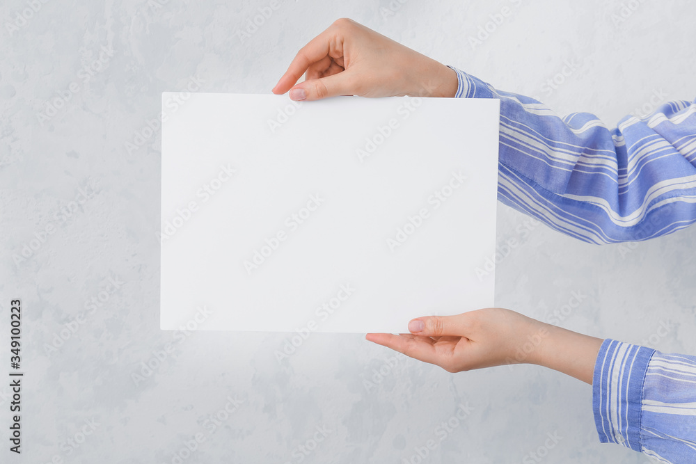 Female hands with blank card on light background