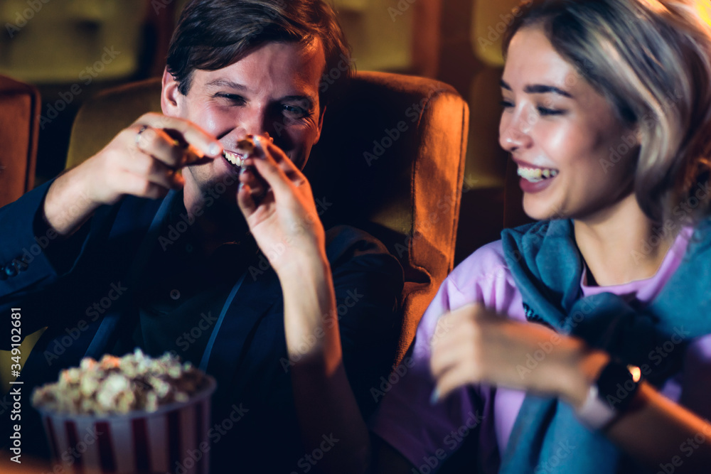 Caucasian lover enjoying to watch movie and eating popcorn together in the cinema