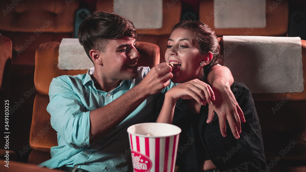 Men and women are eating and tossing popcorn was fun into their mouths in theater