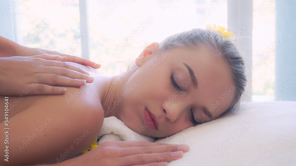 Relaxed woman getting back massage in luxury spa with professional massage therapist. Wellness, heal