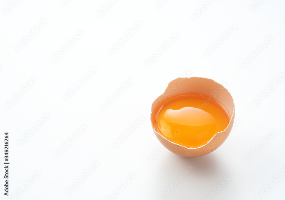 A broken egg placed on a white background with copy space