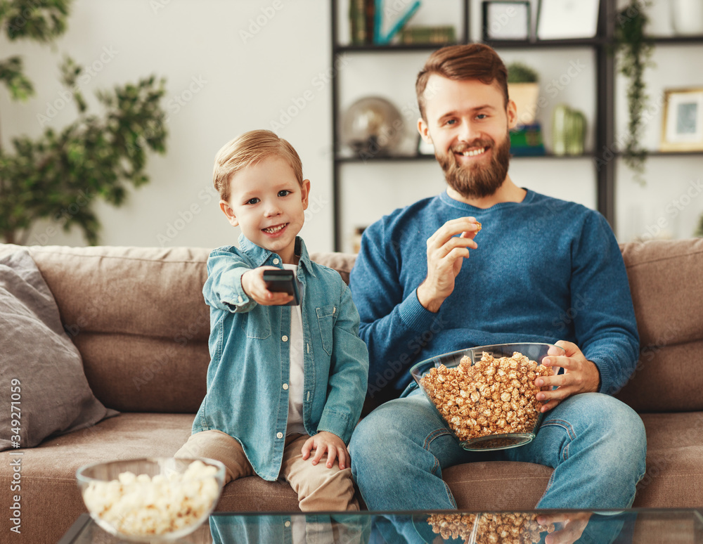 Positive father and son watching movie at home.