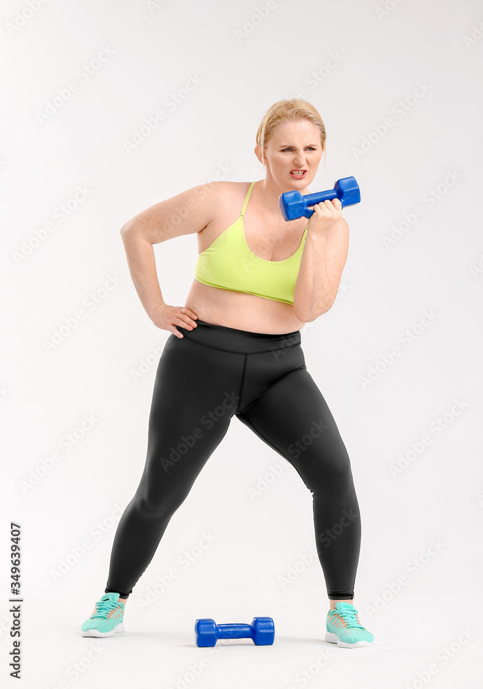 Woman with excess weight training on white background