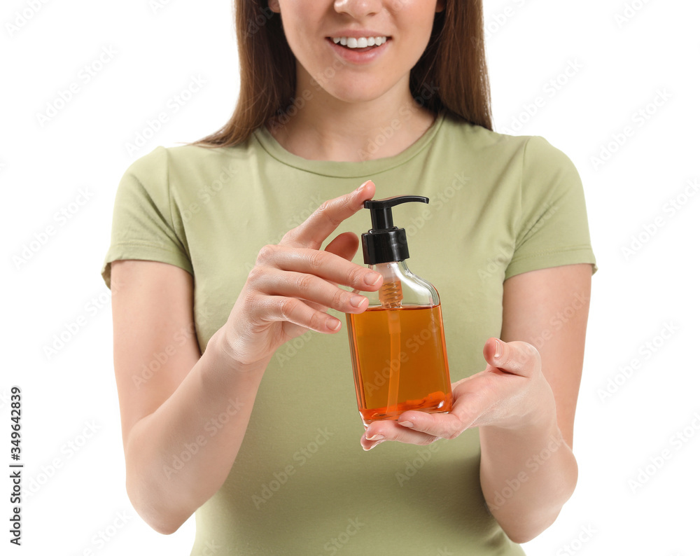 Young woman with cosmetics in bottle on white background