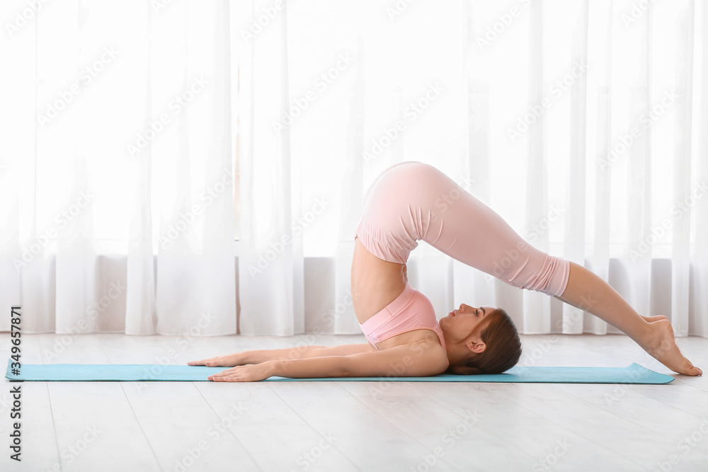 Sporty young woman training at home