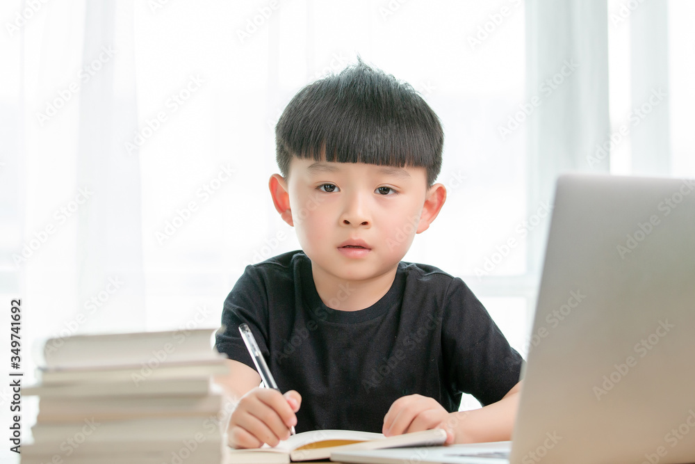 Asian little boy doing online class
