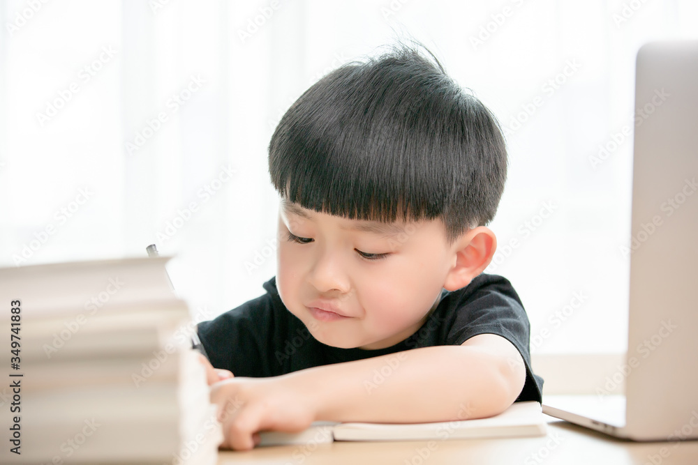 Asian little boy doing online class
