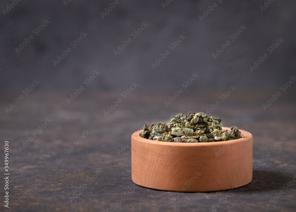  Green tea dry in wooden cup on m with a close-up copy of the space. Healthy organic vitamin herbal 