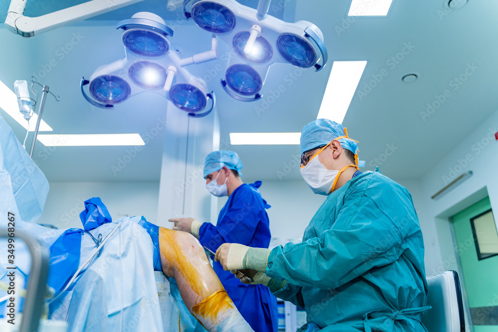 Surgeons working in operating room. Hospital background. Two male doctors at work. Circular shooting