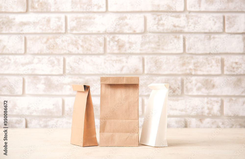 Paper bags on table against light background