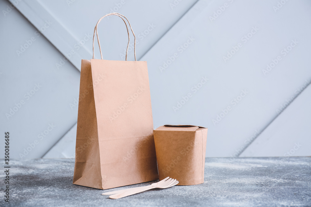 Paper bag and box with food on table