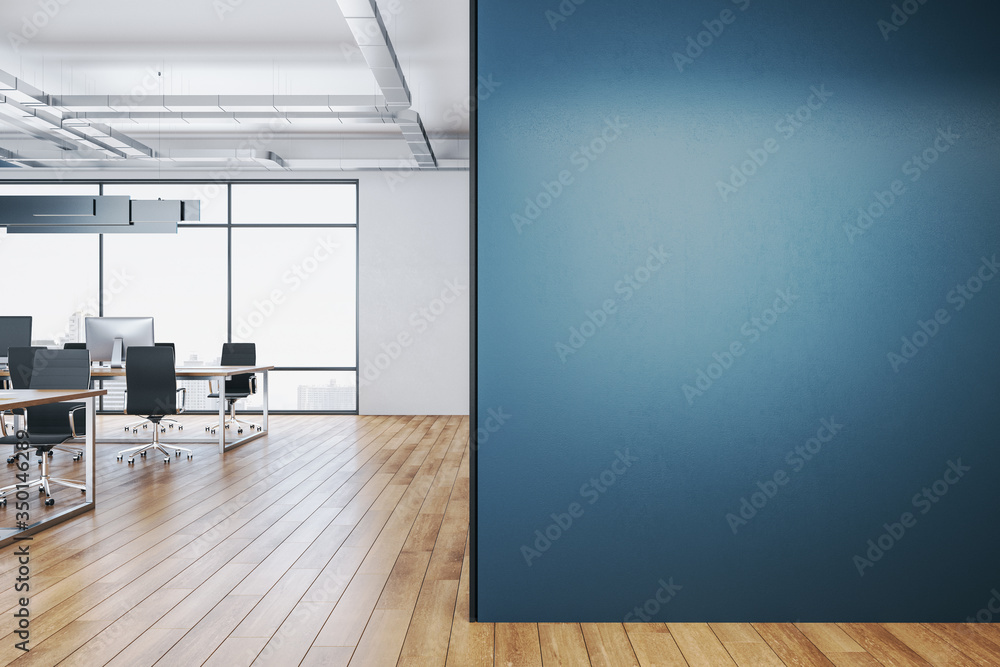 Clean coworking office interior with blank blue wall.