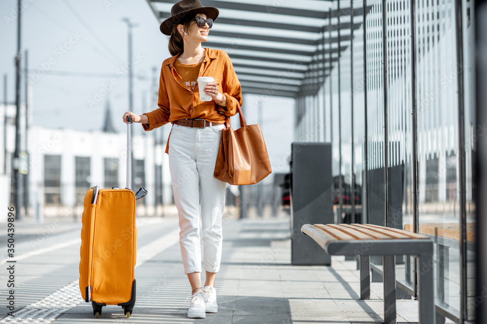 在运输站拿着行李的年轻女性旅行者