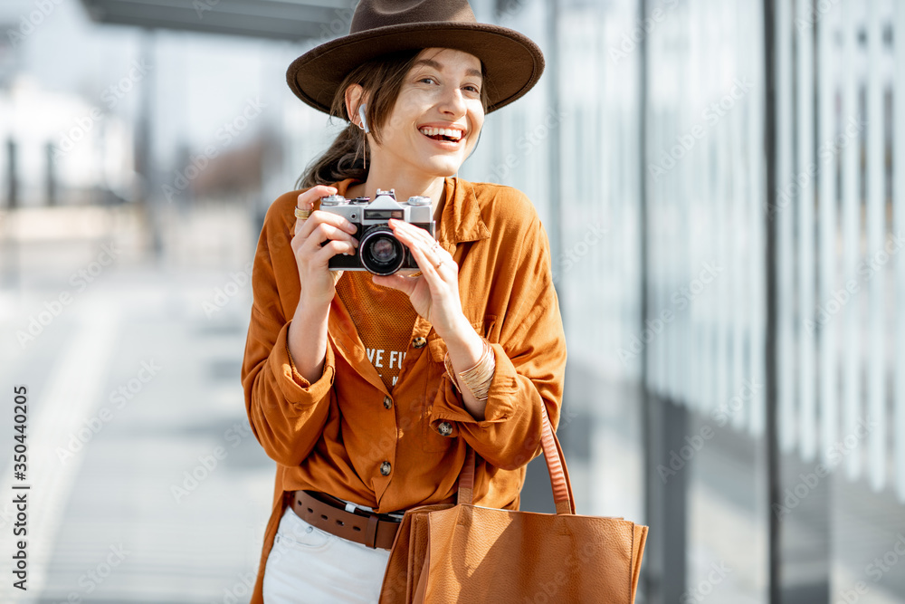 Young woman traveling with photo camera in the modern city