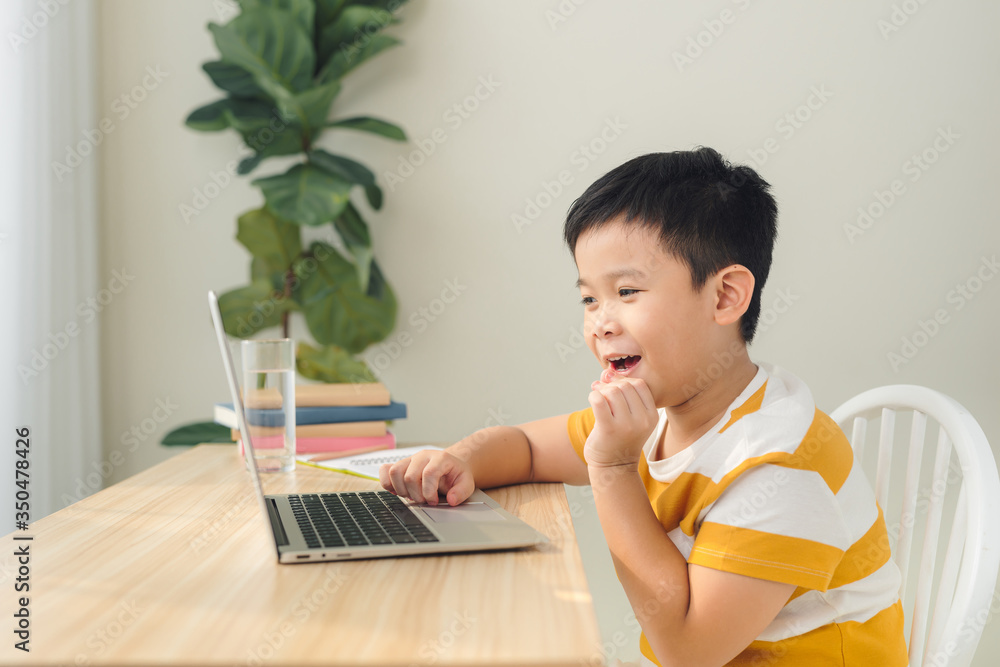 A schoolboy boy studies at home and does school homework